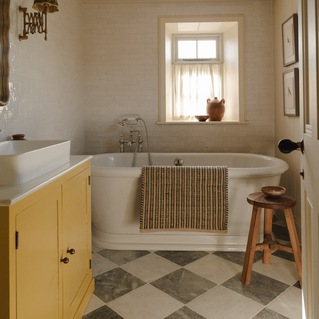 Bathroom with a bathtub, sink, and wooden stool.