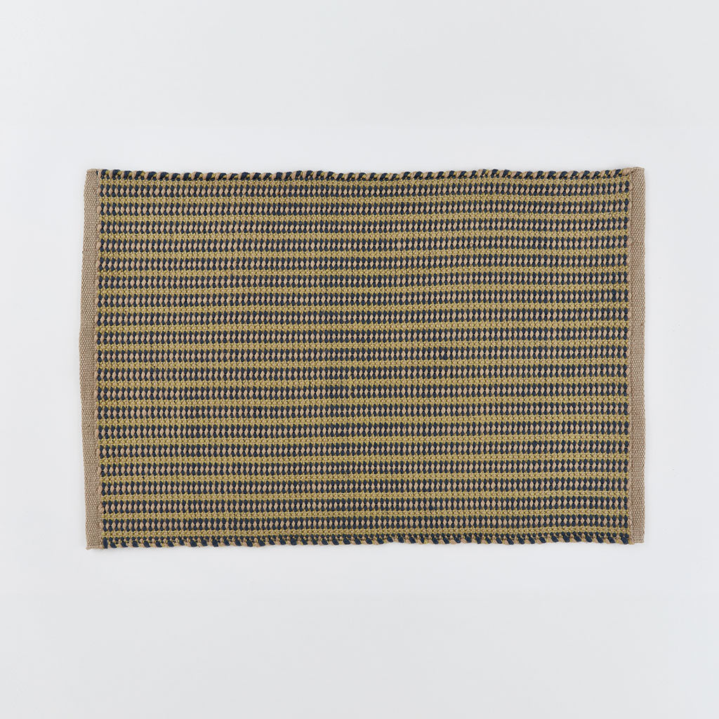 A striped rug in navy blue and gooseberry yellow