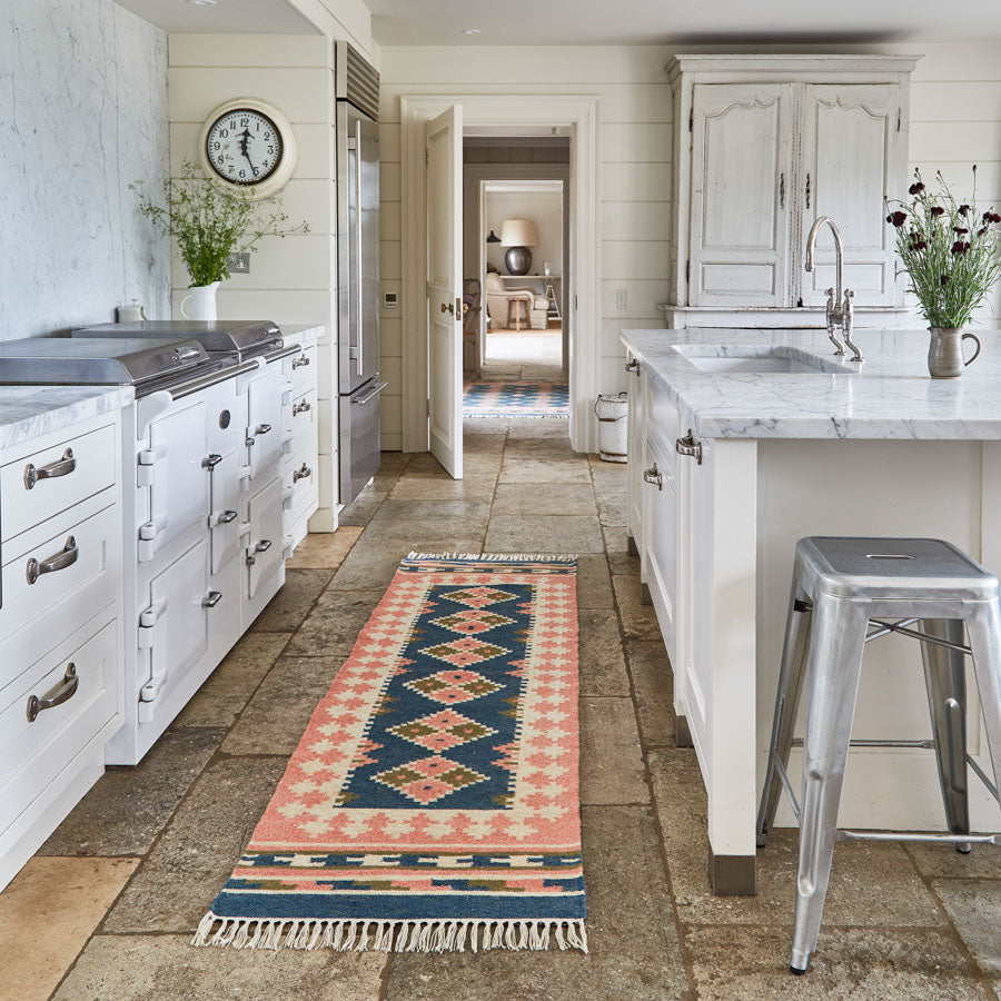 a plaster pink and dark blue geometric rug in a kitchen