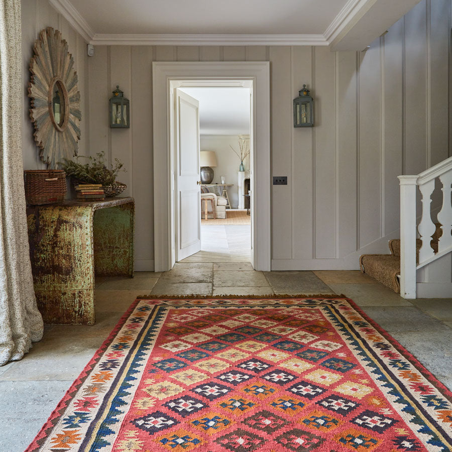 Red geometric patterned kilim in a hallway
