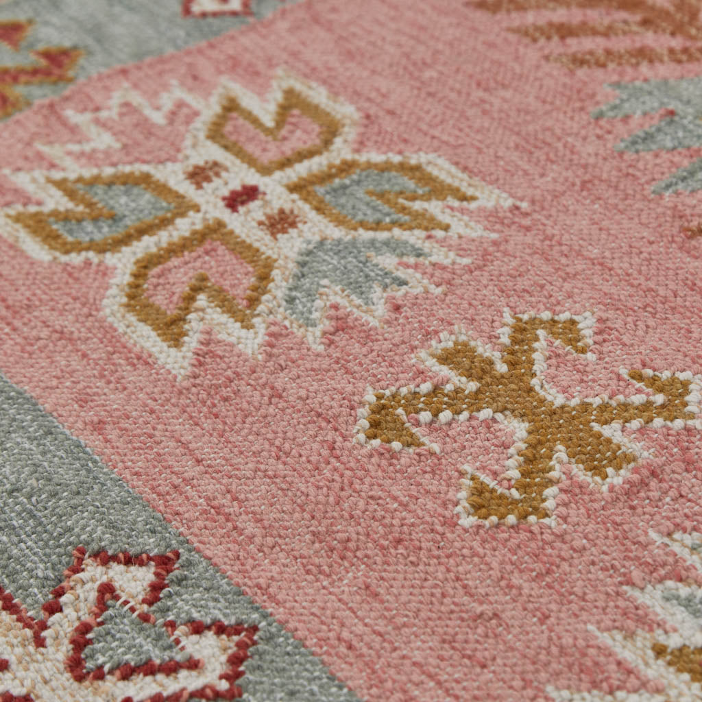 A pink, pale blue and neutral coloured rug