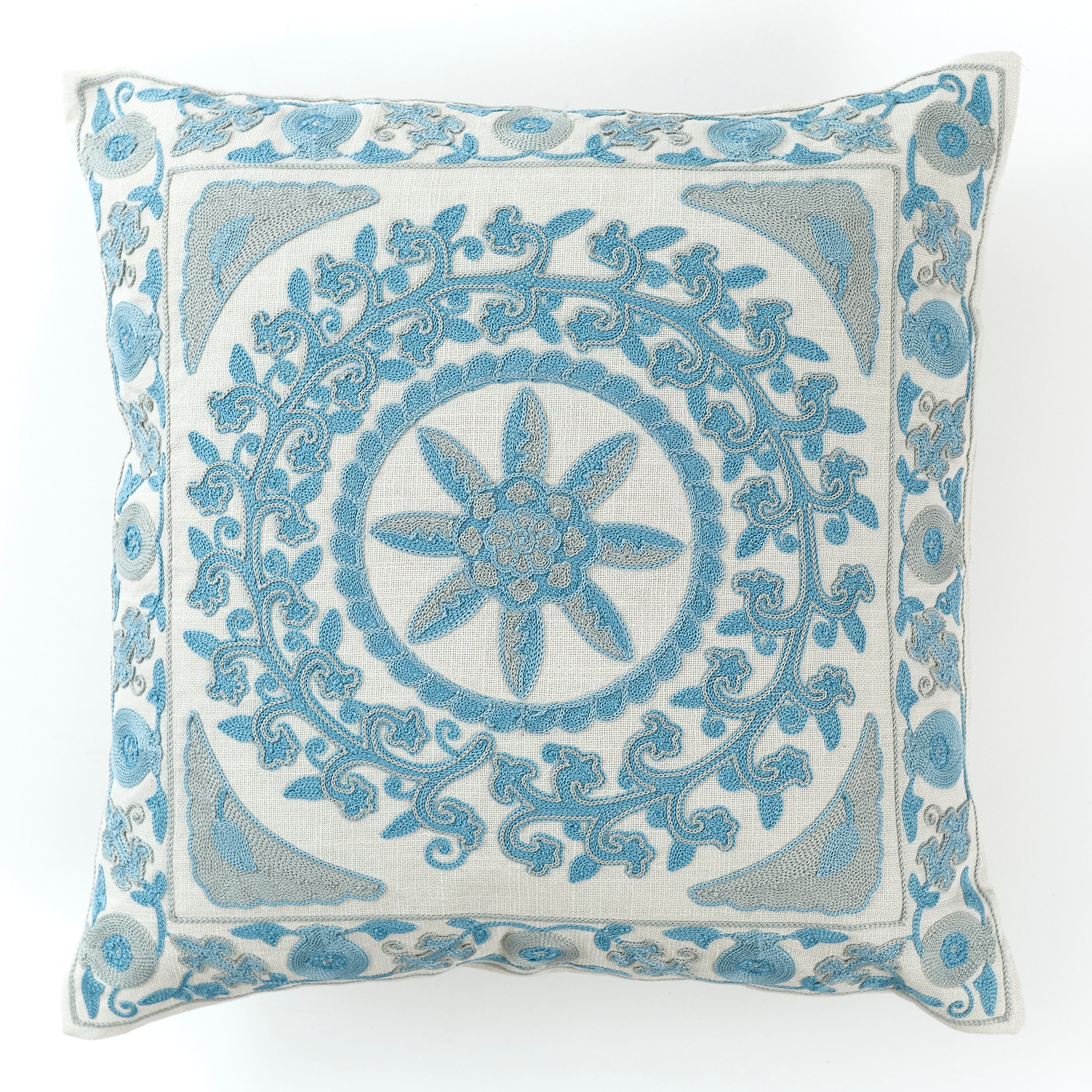 Blue embroidered cushion in a floral geometric pattern placed on white background.