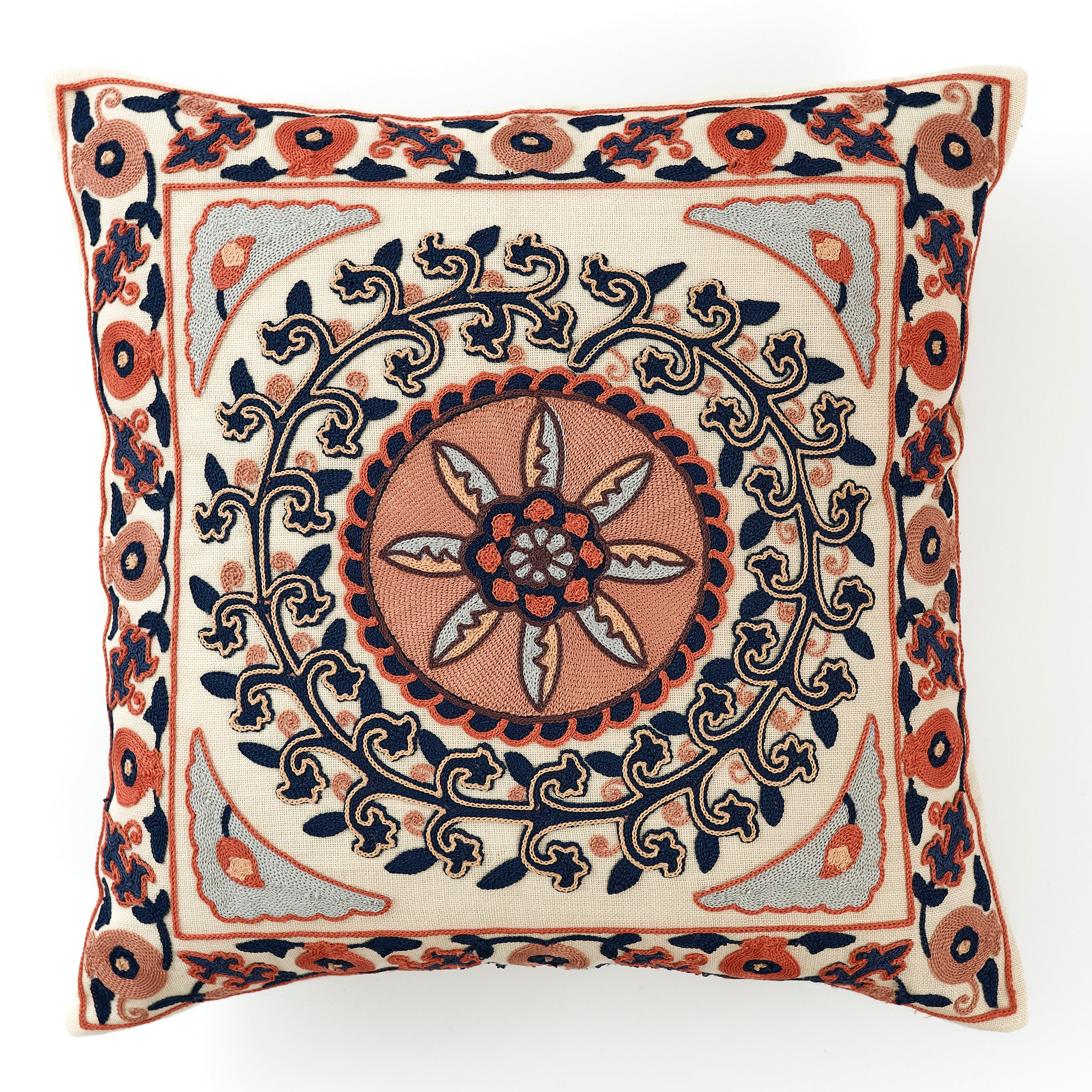 Embroidered cushion with a coral and navy intricate floral and geometric pattern on a white background.