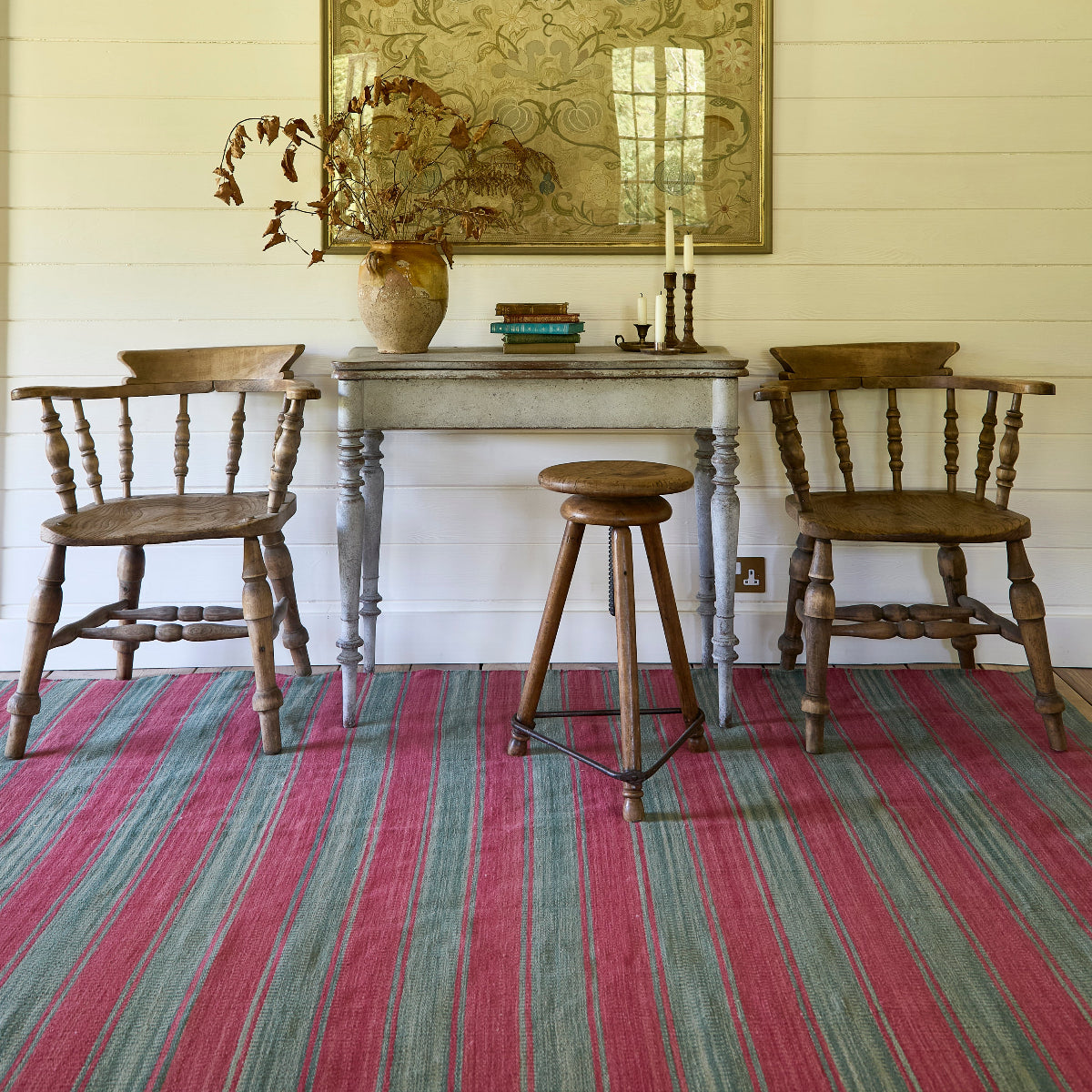 Dining room with wooden table and chairs on a striped rug