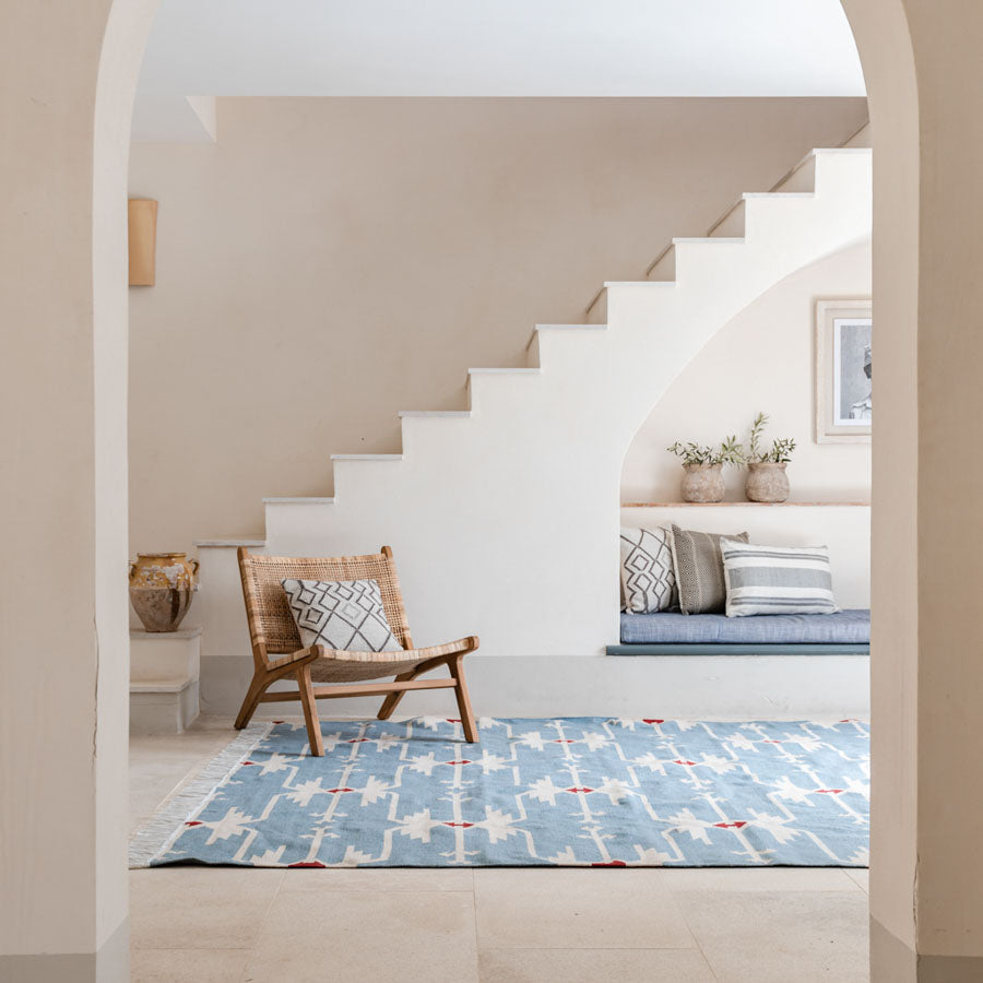 a patterned blue rug in the hallway