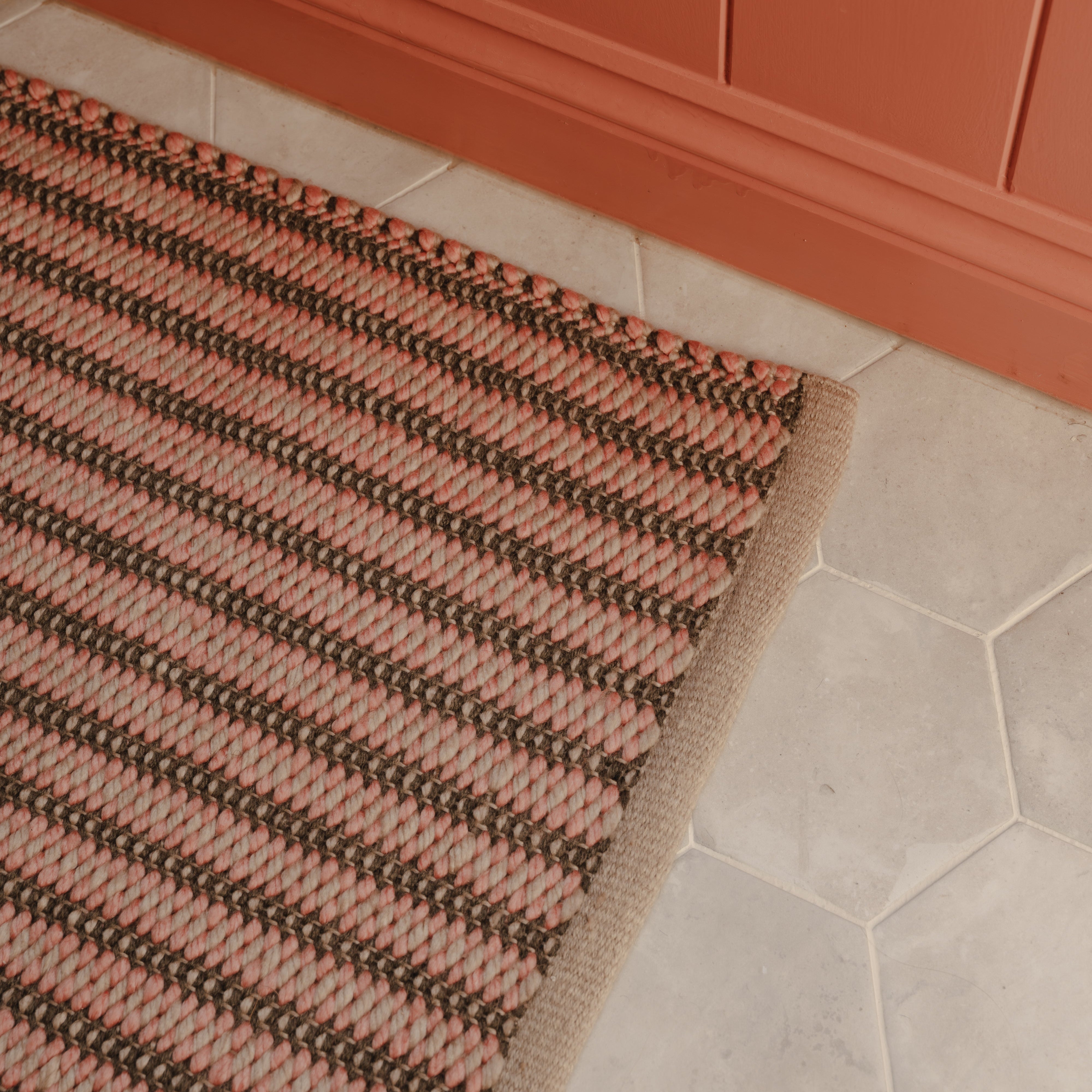detail of coral and charcoal striped woven rug