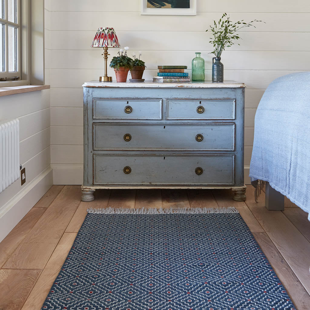 indra indigo rug at the end of the bed