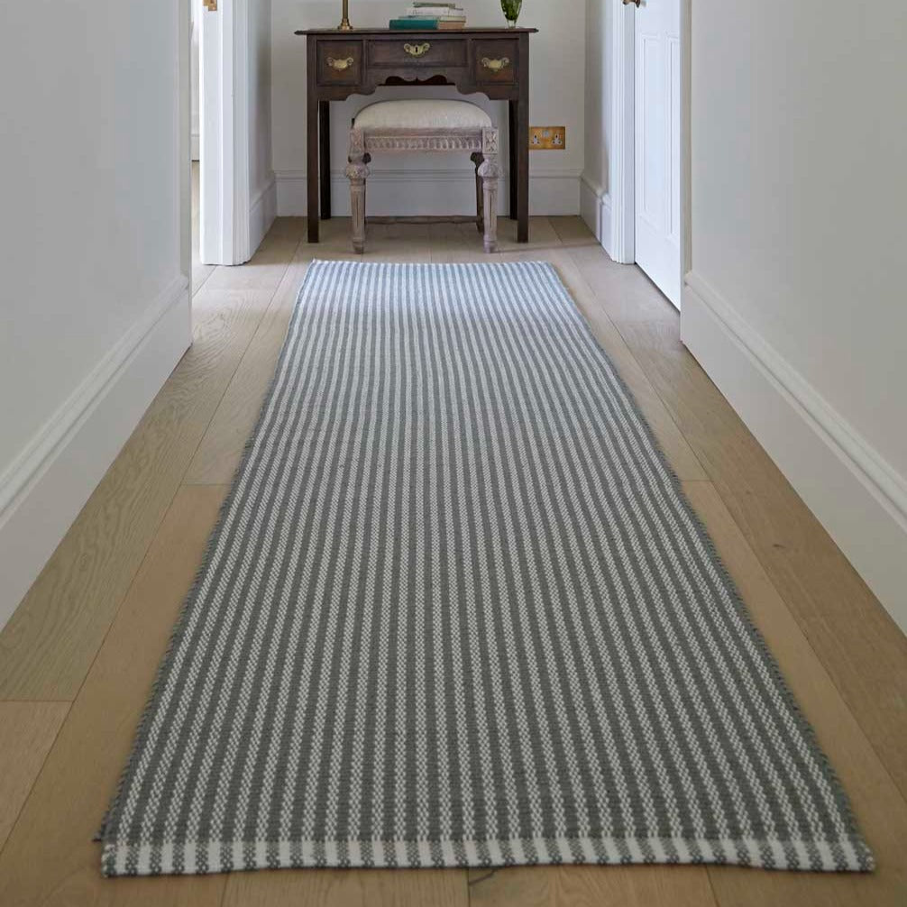 A dove grey striped rug, in the hallway