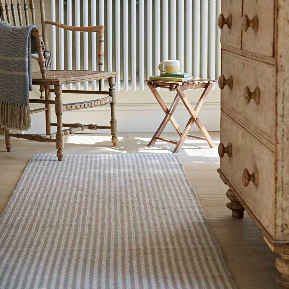 Striped beige rug in a hallway.