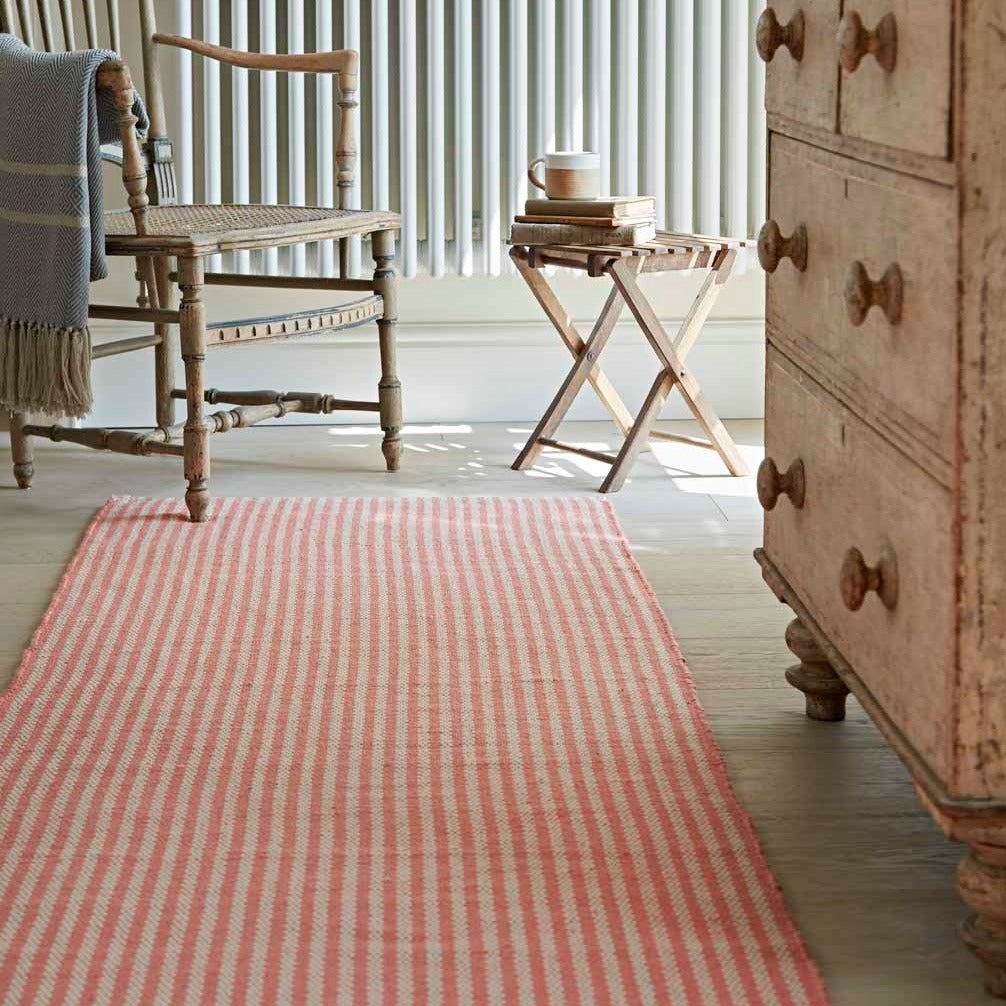 striped coral rug in a rustic hallway