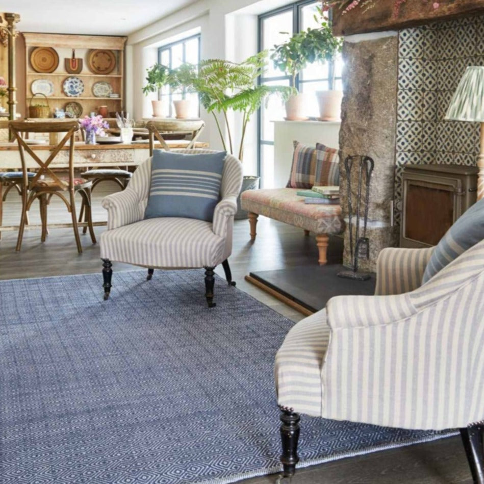 A navy blue diamond pattern rug placed by a fireplace in a living room