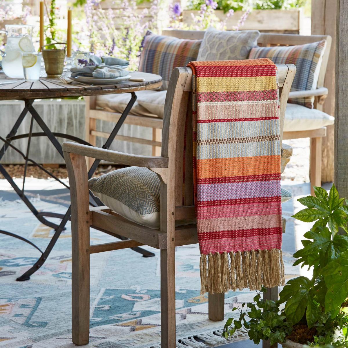Darjeeling rainbow throw draped over the back of a chair outdoors.