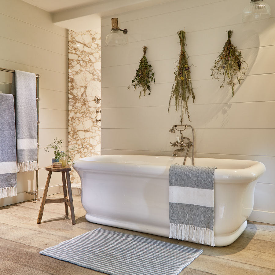 A dove grey striped rug, in a bathroom 