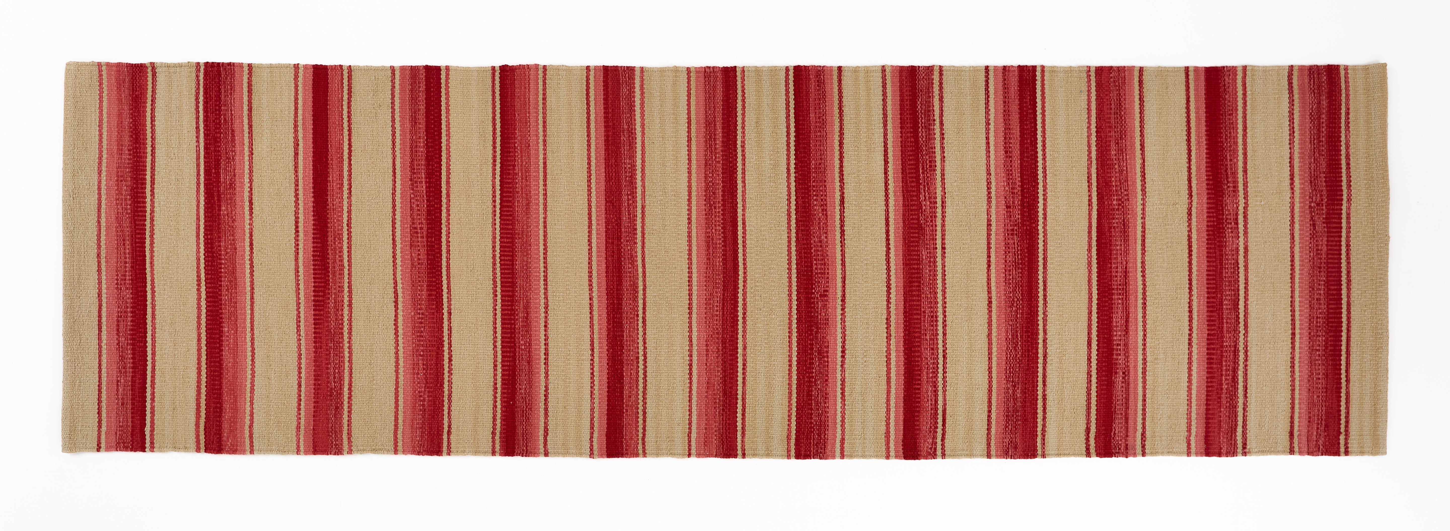 Striped red, pink and beige runner rug on a white background.