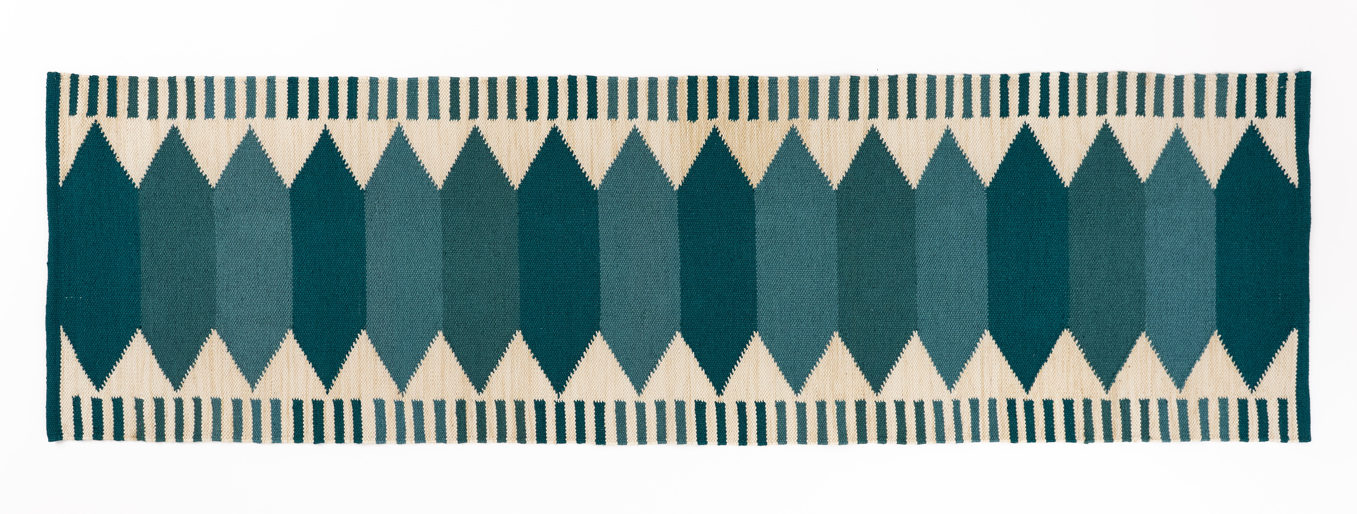 Runner rug with teal geometric pattern on a white background.