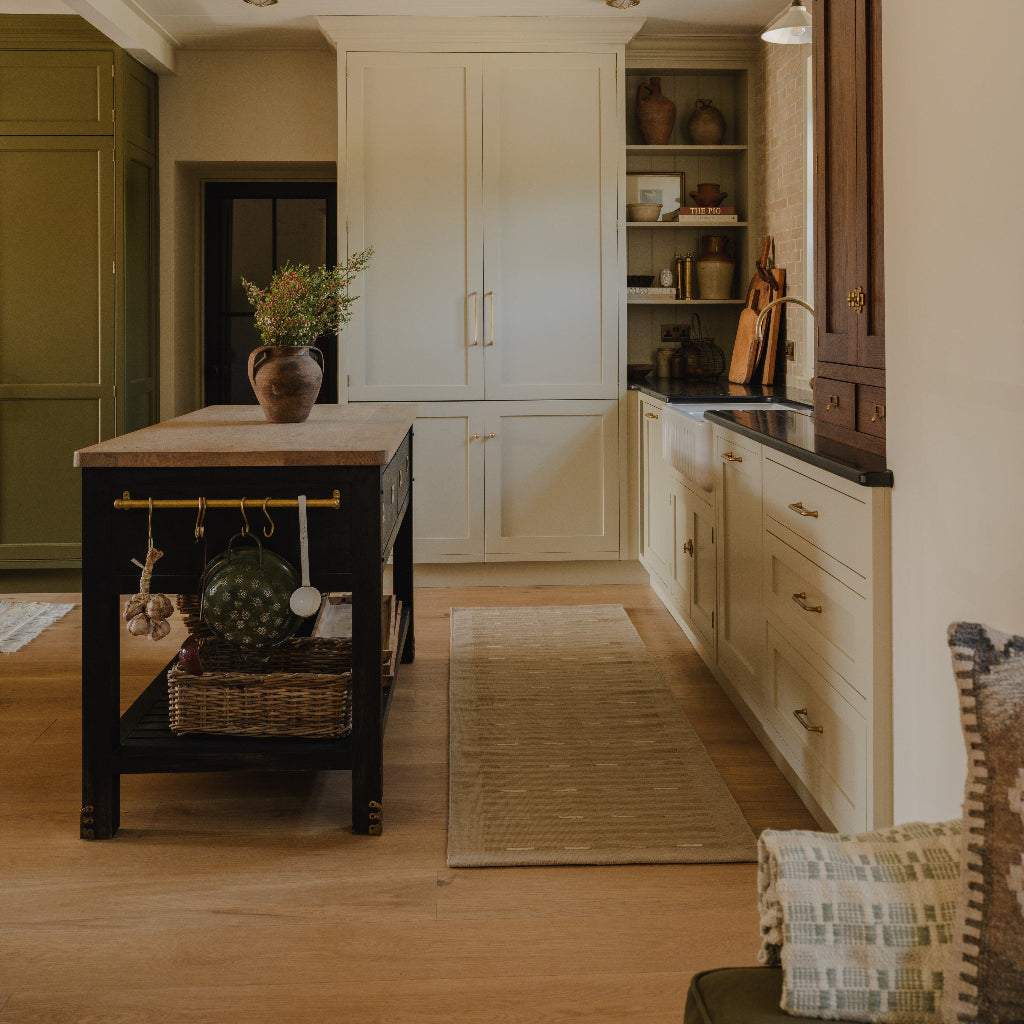 Modern kitchen with wooden island, white cabinets, and decorative elements.