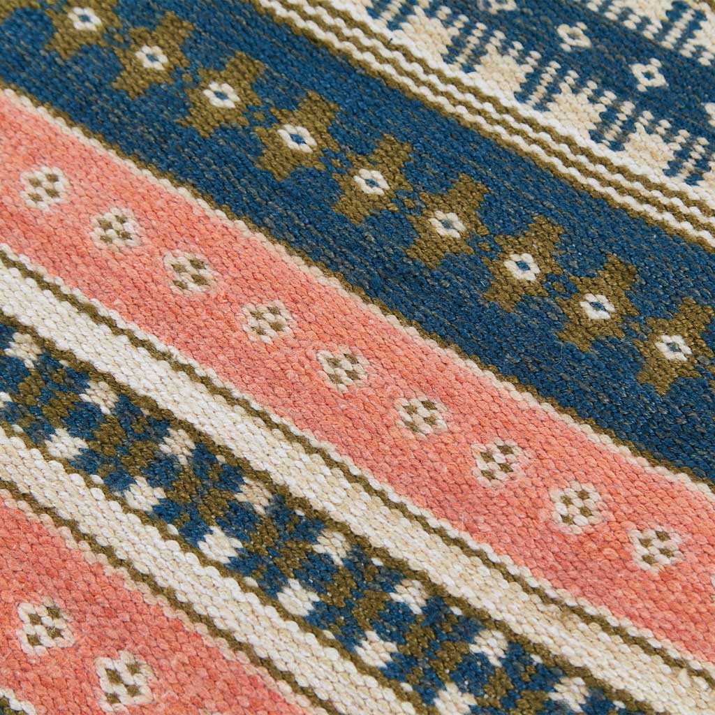 a blue, coral and olive striped rug detail 