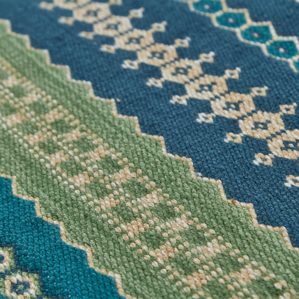A colorful striped rug with green and blue stripes 