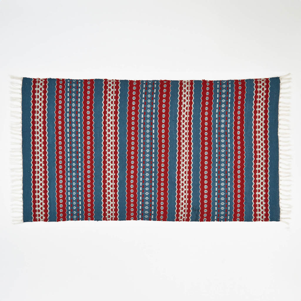 A red and blue striped rug with a geometric pattern 