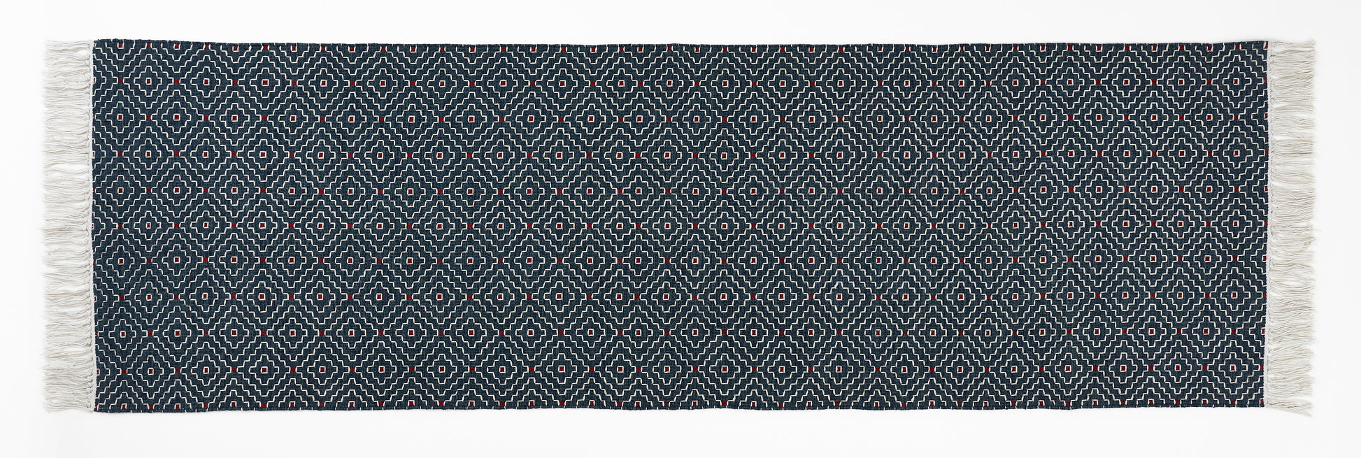 Navy blue woven runner with white geometric pattern and fringes on a white background