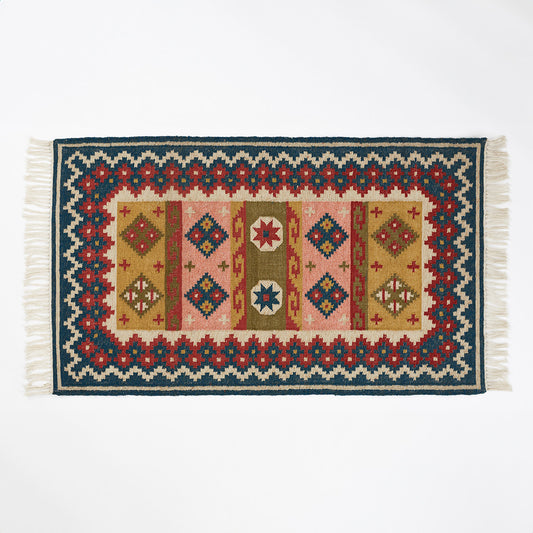 Geometric patterned rug in blue pink red and olive colourways