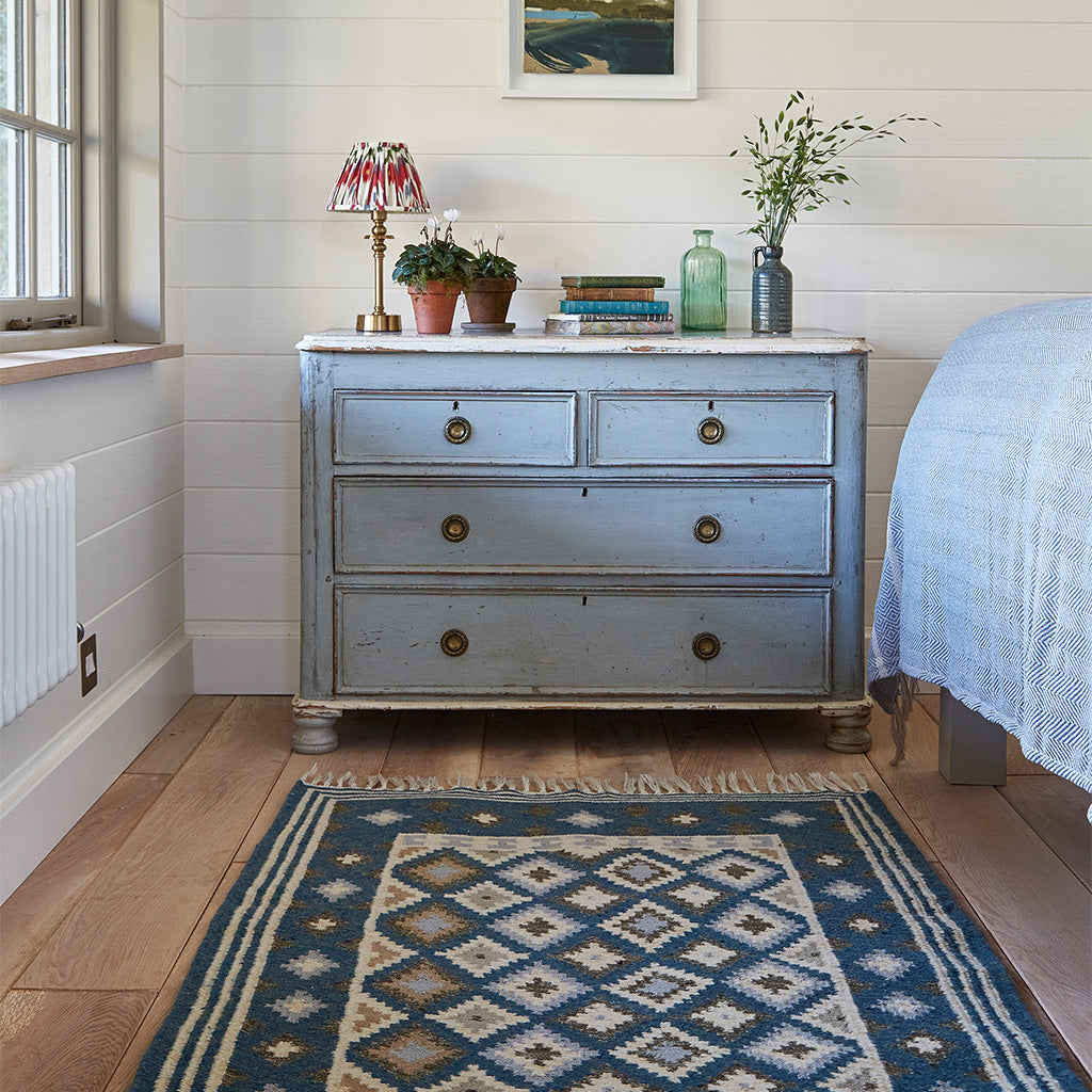blue geometric patterned rug in a bedroom 