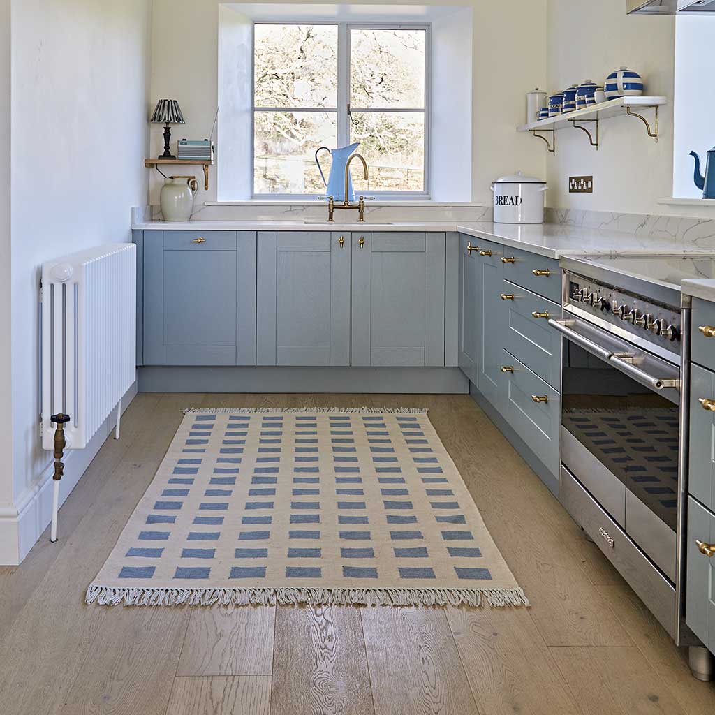 neutral and blue checkered rug in a blue kitchen 